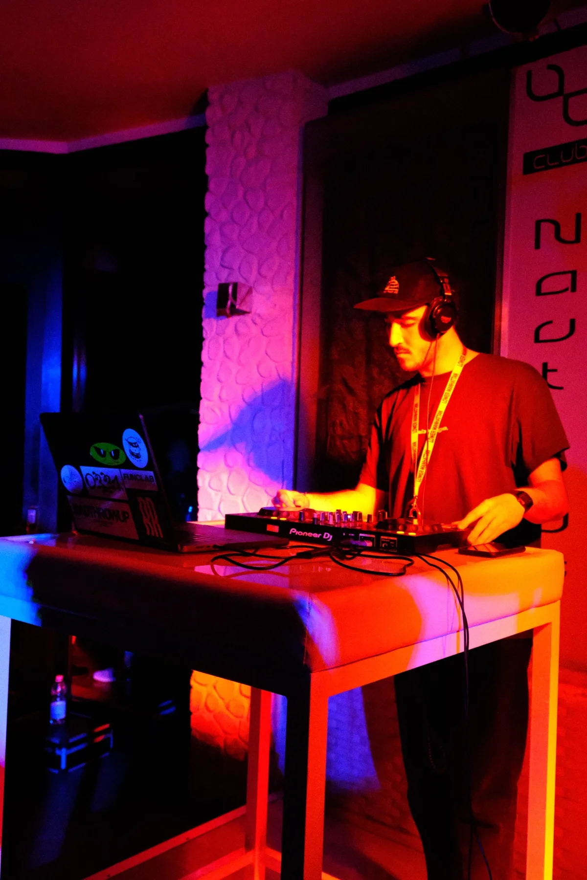 Dj alla consolle con laptop e cassa, illuminazione calda